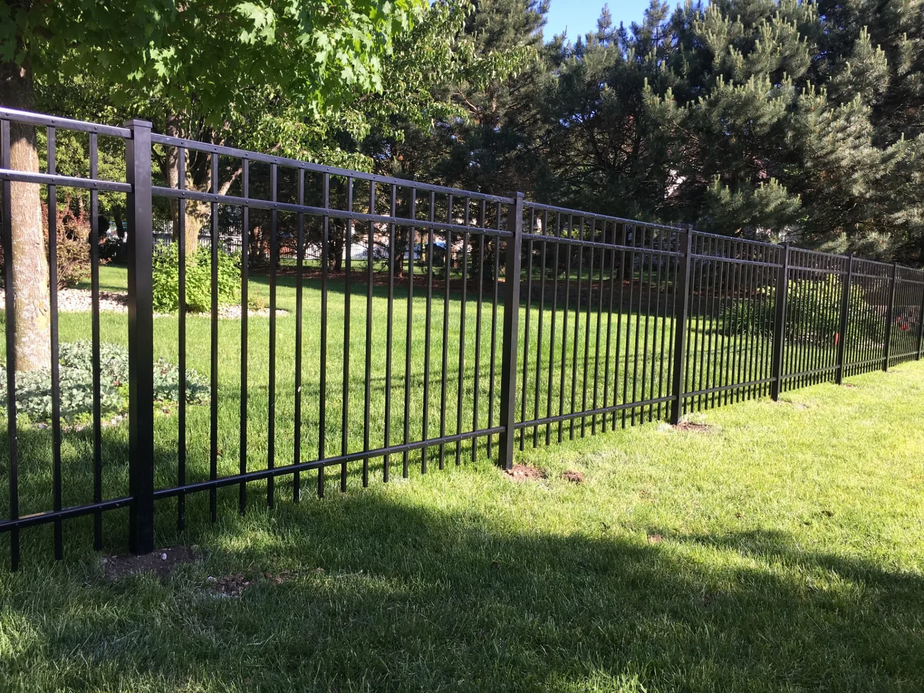 Black Aluminum Fence Along a Tree Line installed by Cedar Mountain Fence